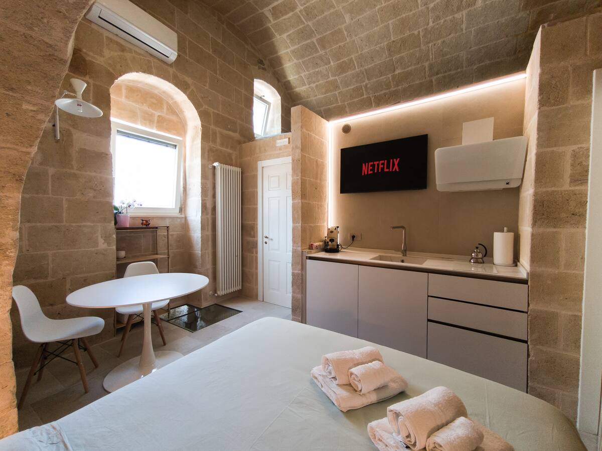 Camera della Eris Suite con letto in alcova sotto l'arco in tufo — foto 6