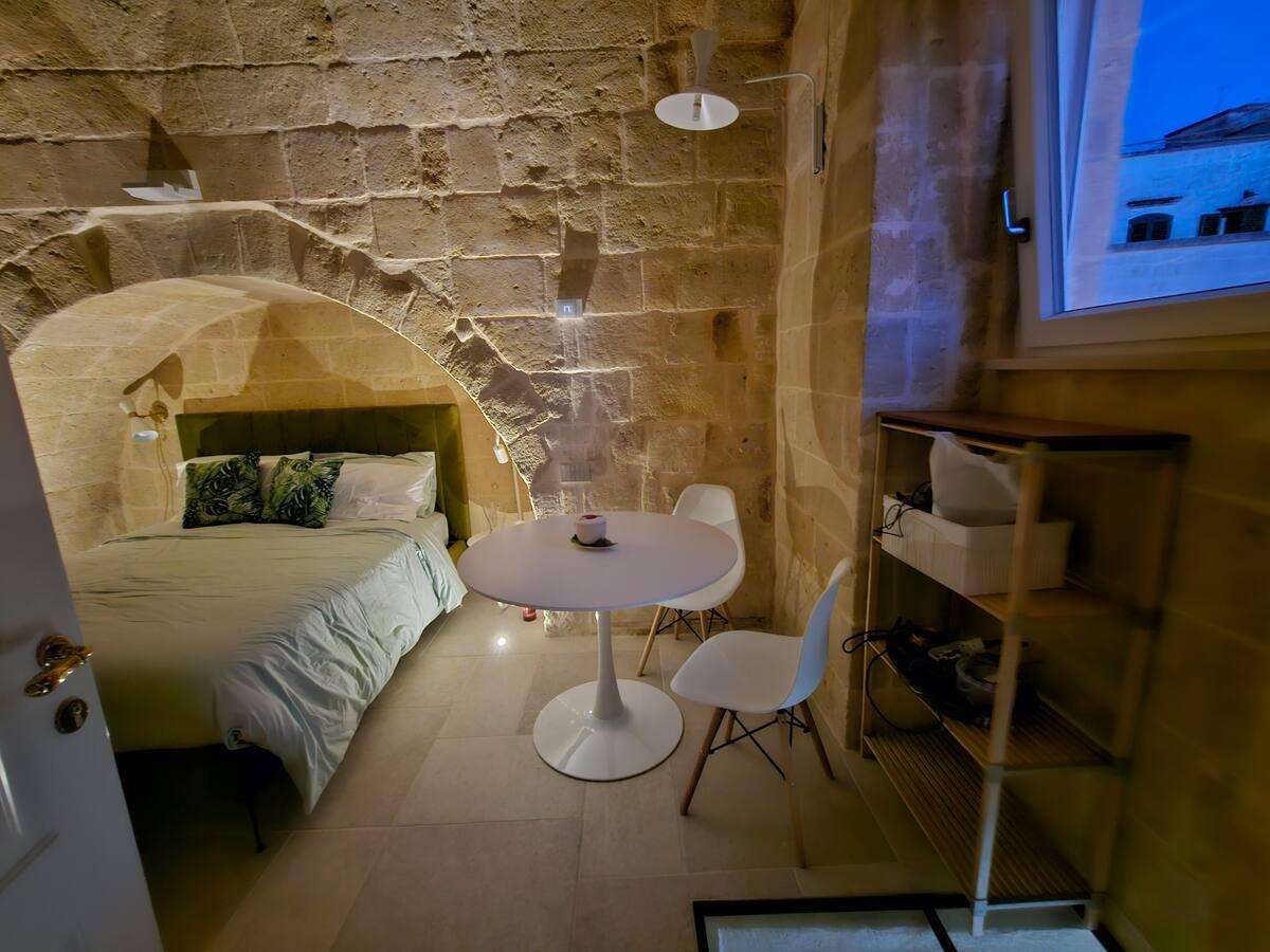 Camera della Eris Suite con letto in alcova sotto l'arco in tufo — foto 4