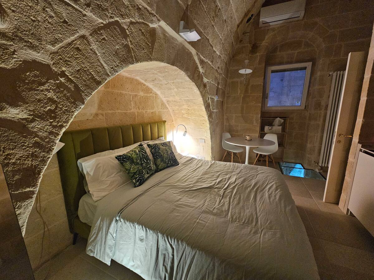 Camera della Eris Suite con letto in alcova sotto l'arco in tufo — foto 3
