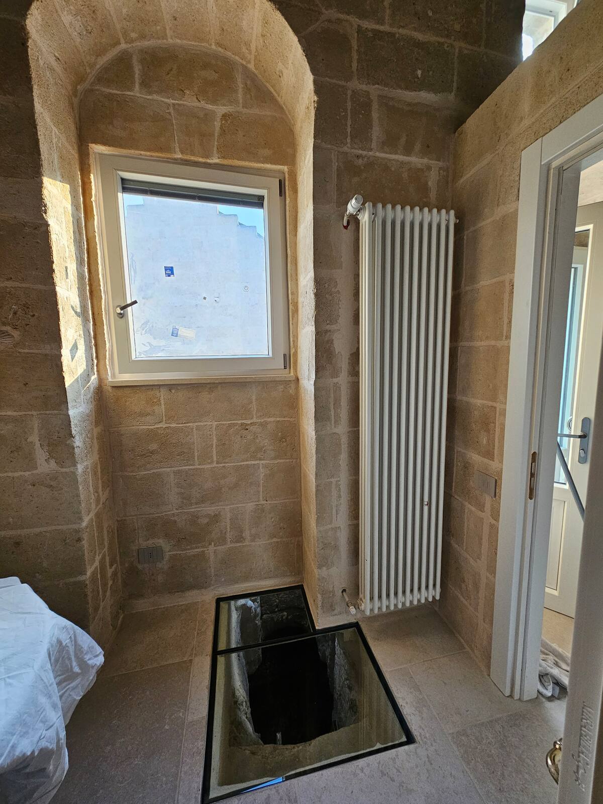 Camera della Eris Suite con letto in alcova sotto l'arco in tufo — foto 10