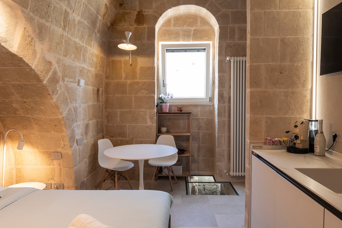 Camera della Eris Suite con letto in alcova sotto l'arco in tufo — foto 7