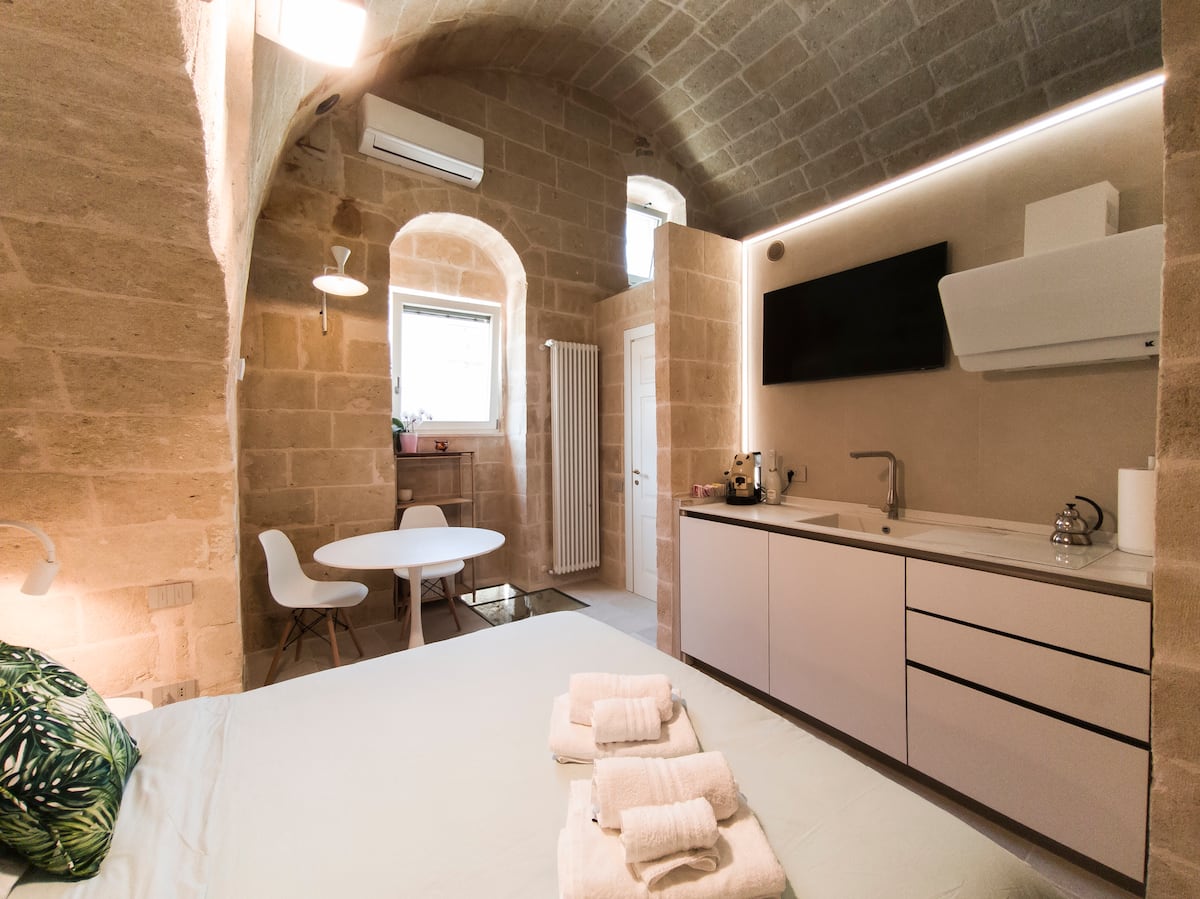 Camera della Eris Suite con letto in alcova sotto l'arco in tufo — foto 5